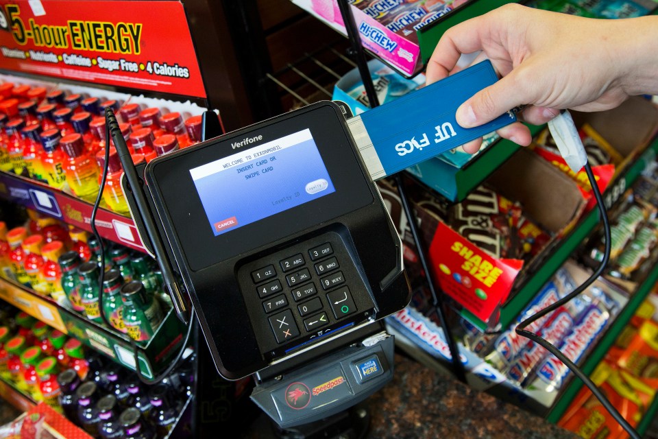A hand inserting a credit card reader detection device into a card reader at a convenience store.
