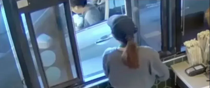 Screenshot of a Starbucks drive-thru window, with a news banner stating Starbucks was ordered to pay $50 million in a burn injury case.