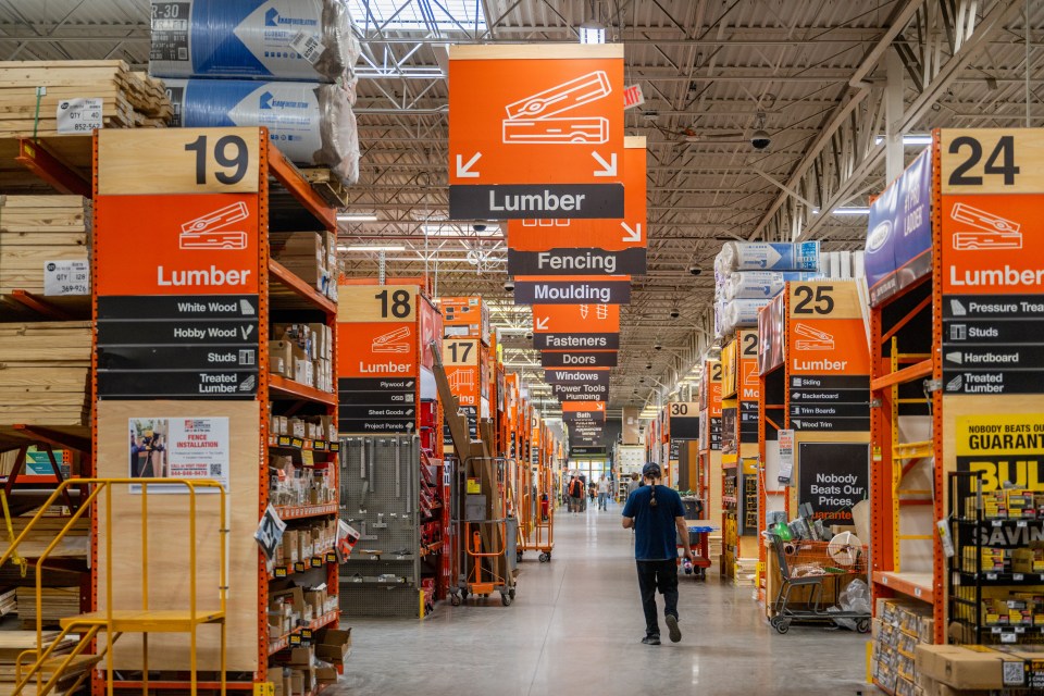 A customer walks through a Home Depot lumber aisle.