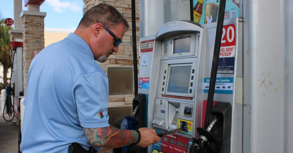 Man paying at a gas pump.