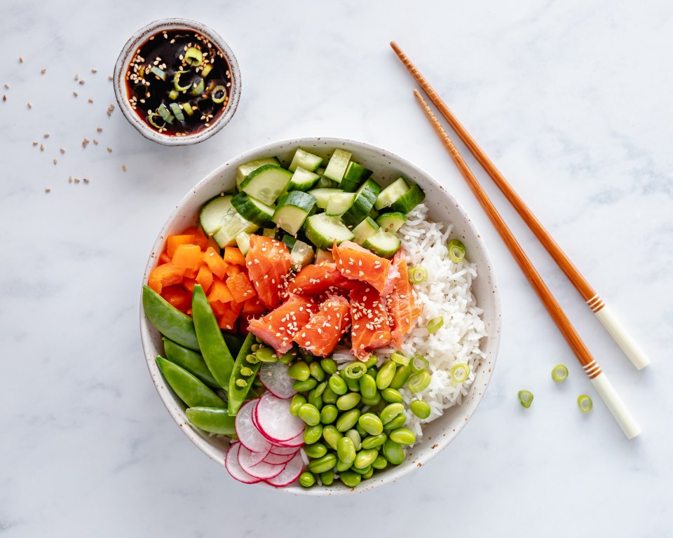 Salmon poke bowl with rice, edamame, and vegetables.