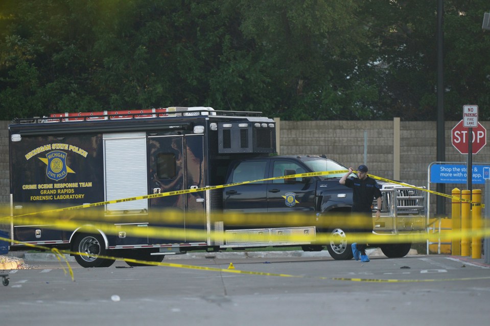 Law enforcement vehicle and officer at a crime scene.