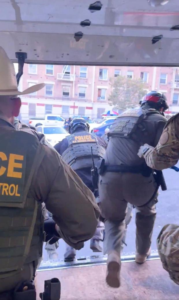 This image taken from video shows U.S. Border Patrol agents jumping out of a Penske box truck during an immigration raid at a Home Depot in Los Angeles, on Wednesday, Aug. 6, 2025. (FOX News/Matt Finn via AP)