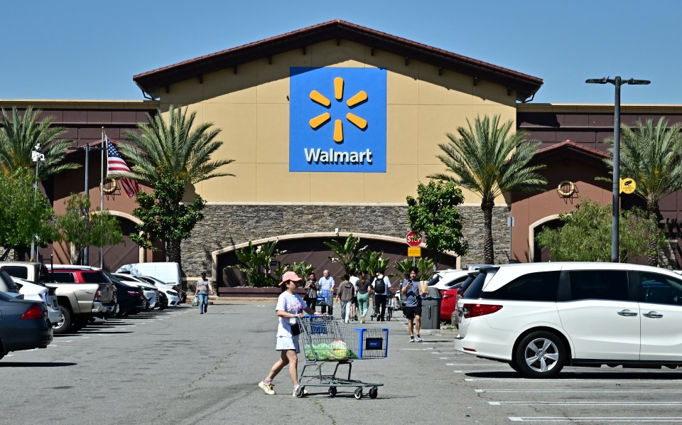 Photo of a Walmart store with shoppers in the parking lot.