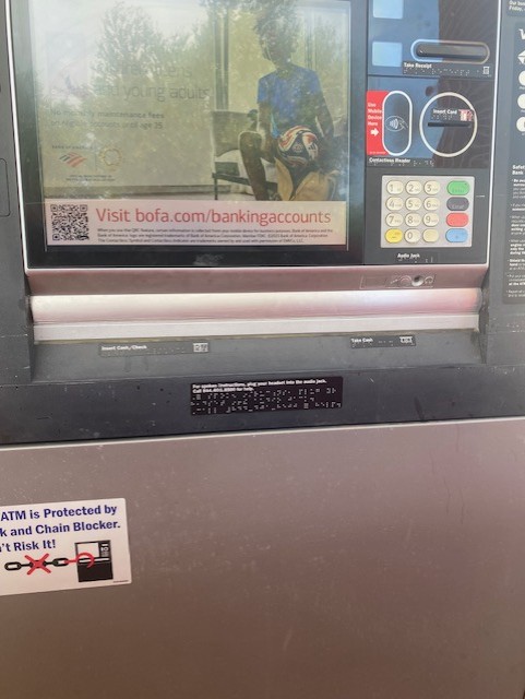 ATM with a sticker warning against cash trapping.