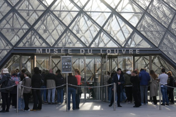 Visitors queue to enter the Louvre museum three days after...